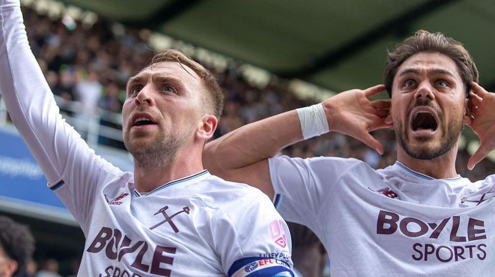 Jarrod Bowen and Konstantinos Mavropanos celebrate with West Ham fans at Millwall