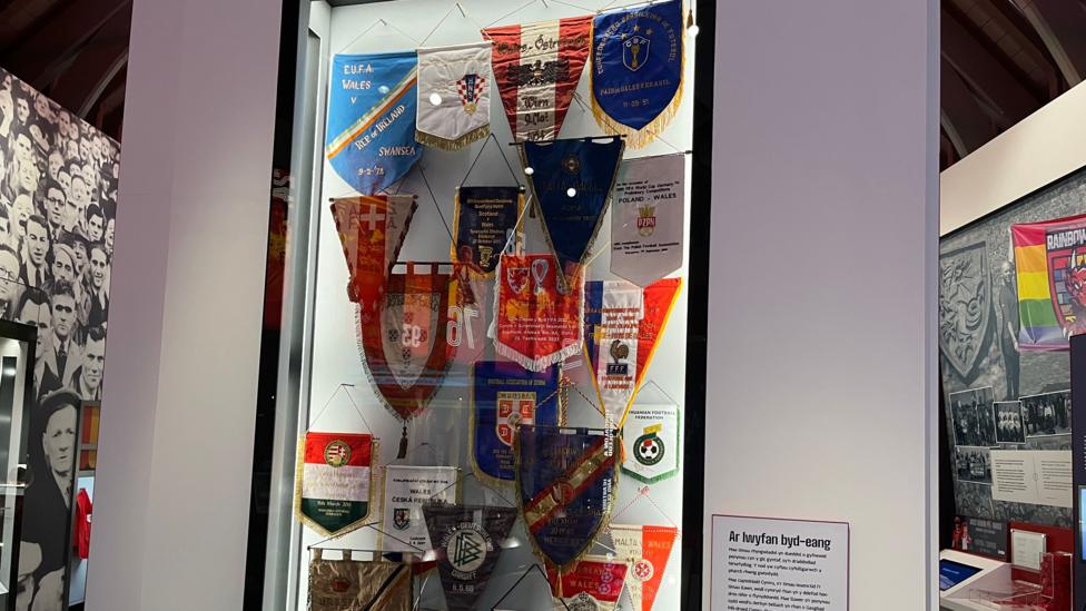 A display of different football pennants overlaid on a board at the football museum.
