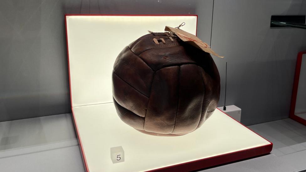 An old brown football on a light-up display.