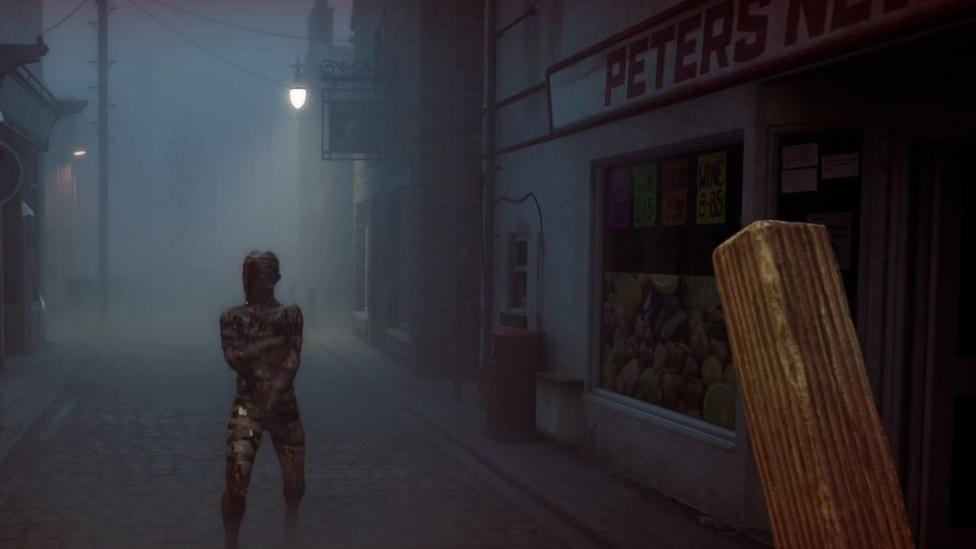 An in-game screenshot showing a faceless monster in a first-person view, with the player holding a plank of wood. They are in the middle of a foggy street with a newsagents on the side.