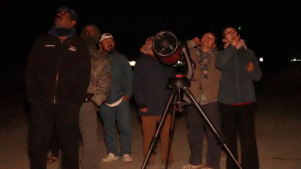 Tsering Yangdol points laser at the sky to help tourists spot stars visible to the naked eye
