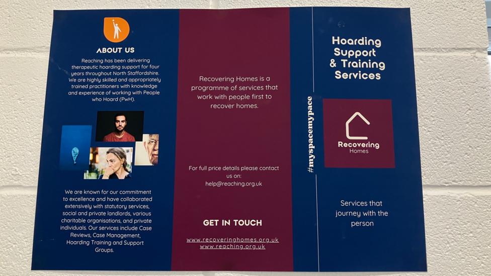 A poster on a white wall highlighting the hoarding support and training services the community interest company offers