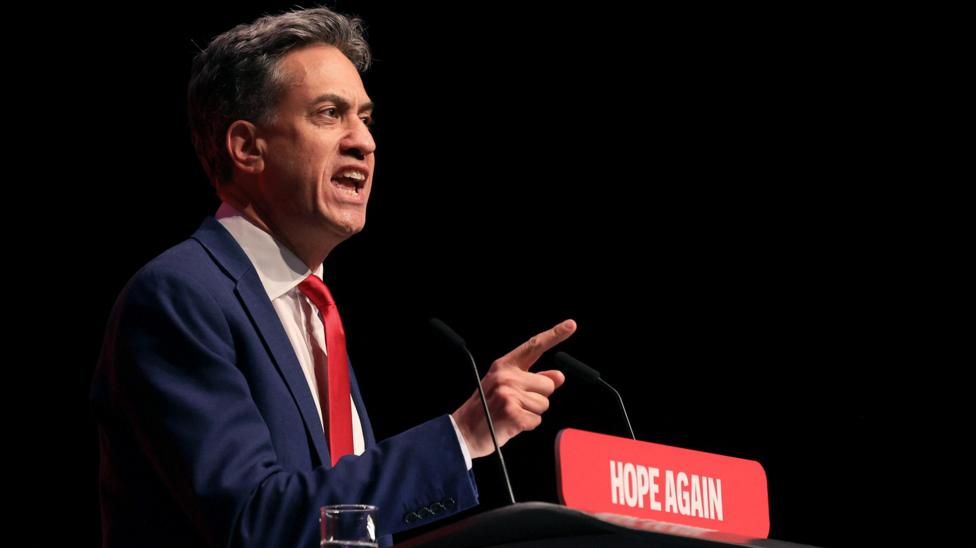Ed Miliband, in a suit and tie, addresses Labour's annual conference. The podium slogan is "Hope Again".