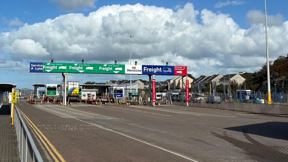 The freight check-in area at Holyhead port with different lanes for the different operators and a very prominent gantry over the top indicating which lane is which.