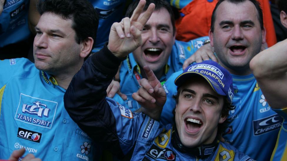 Fernando Alonso holds up two fingers on his right hand as he celebrates winning the 2006 drivers' championship with his Renault team