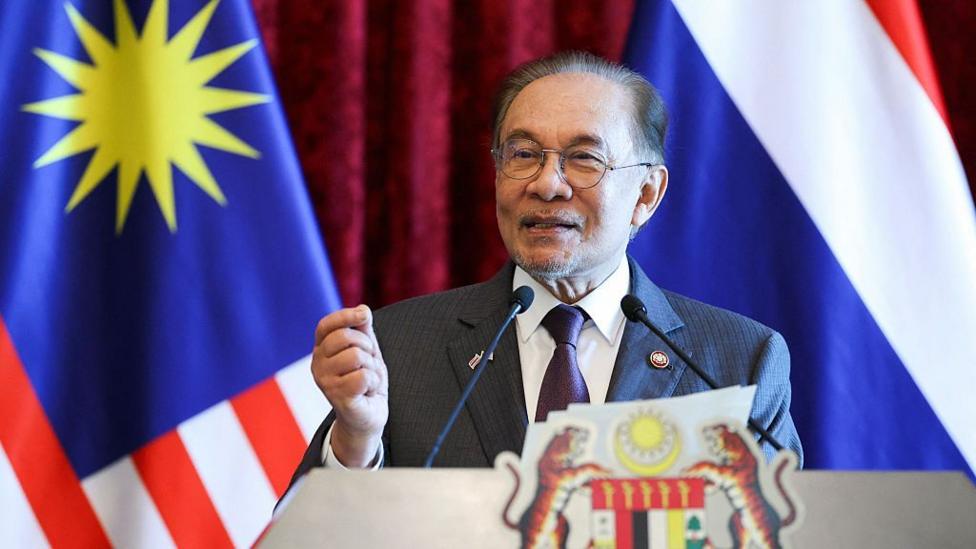 Malaysian Prime Minister Anwar Ibrahim standing behind a podium