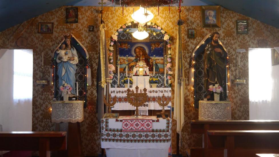 An interior view of the Ukrainian chapel in Lockerbie with an altar, statues and lights and candles