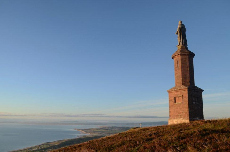 Monument to the Duke of Sutherland. The monument is a stone tower-like structure with a statue of the duke on top.