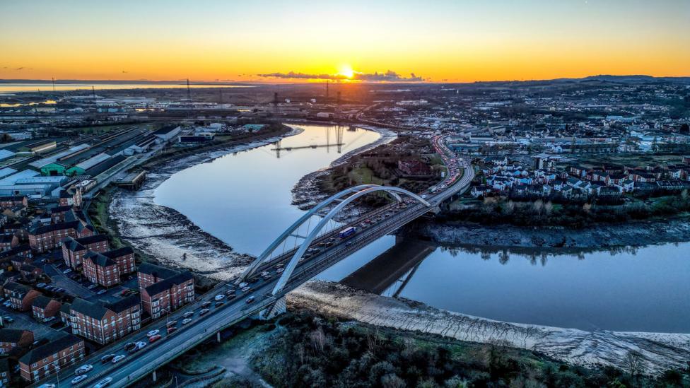 An aerial view of Newport showing the river and a bridge at sunset