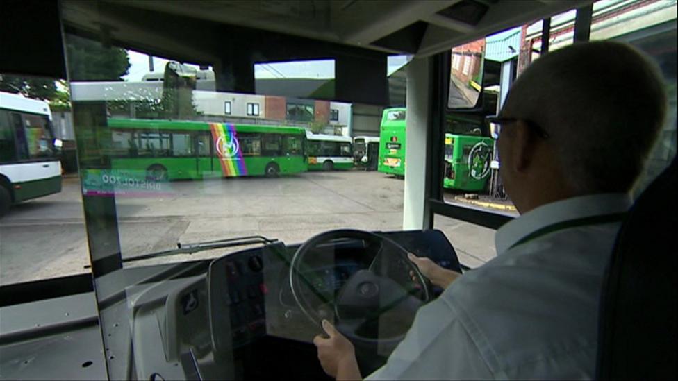 A driver on a Newport Bus pulling into a depot, with other green buses parked around the edges of the stand