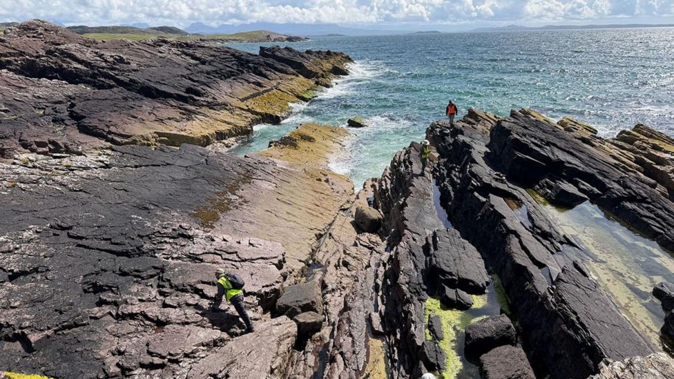 Members of the Nasa-led expedition inspect a large area of flat rocks on the sea shore at Clachtoll.