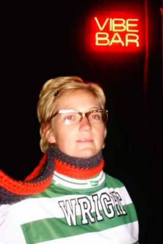 A blonde woman - wearing a red and black scarf - sports Kevin's green and white hooped Celtic shirt outside the Vibe Bar in Barcelona.