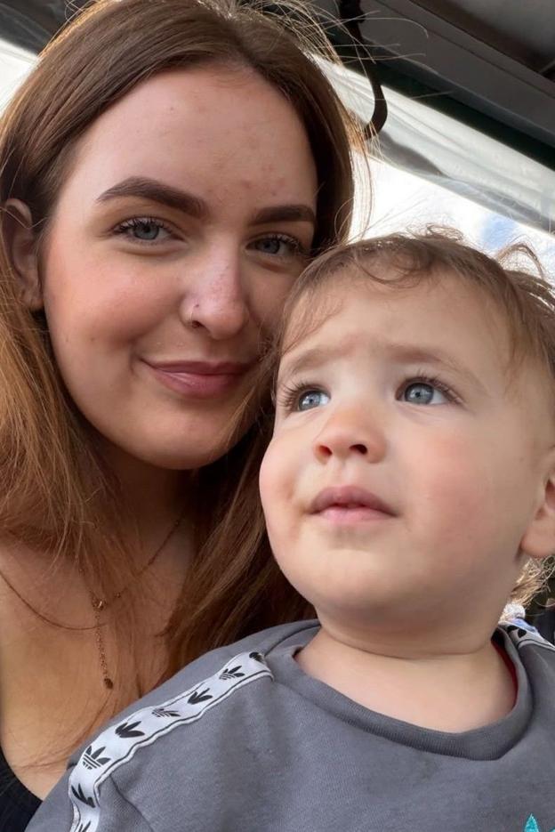 Selfie photograph of Sarah Durgan and her son, Noah. Sarah (left) has warm brown hair and blue eyes and smiles at the camera. Her son sits on her lap and has blue eyes and brown hair and wears an adidas sweatshirt.