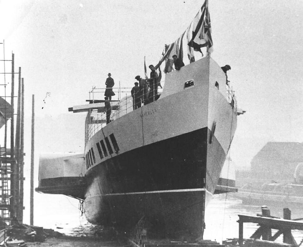 Historic black-and-white photograph of the paddle steamer Waverley at its launch on 2 October 1946, with people standing on the deck as the newly built vessel enters the water beside a shipyard.