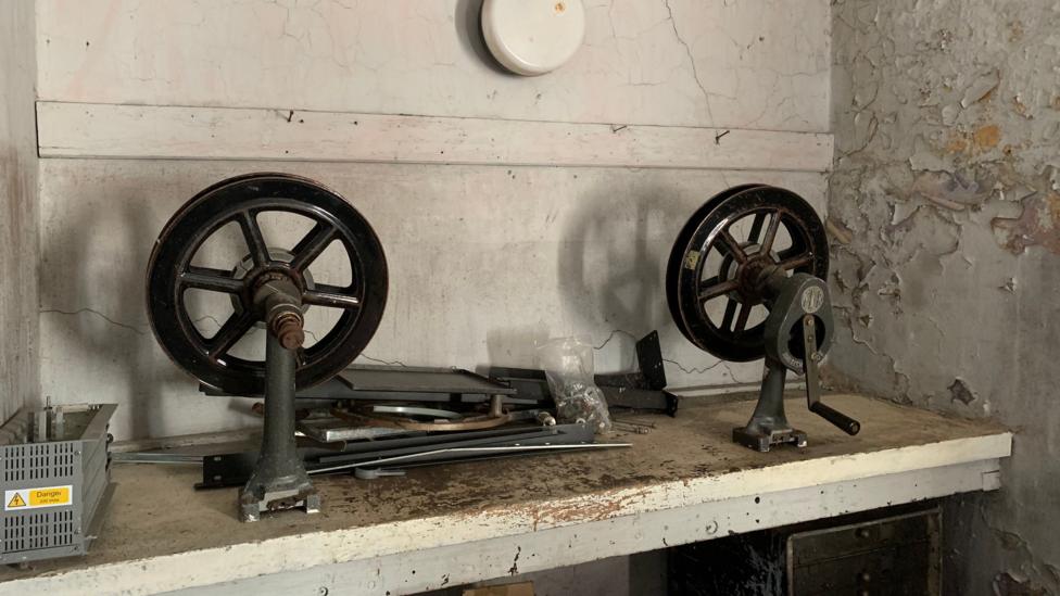 What look like two reels for winding film with a handle on one of them