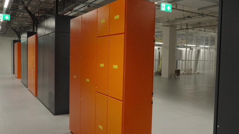 Inside a data centre in Tower Hamlets with orange and grey metal units inside.
