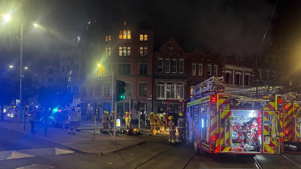 A fire engine outside an alight building.