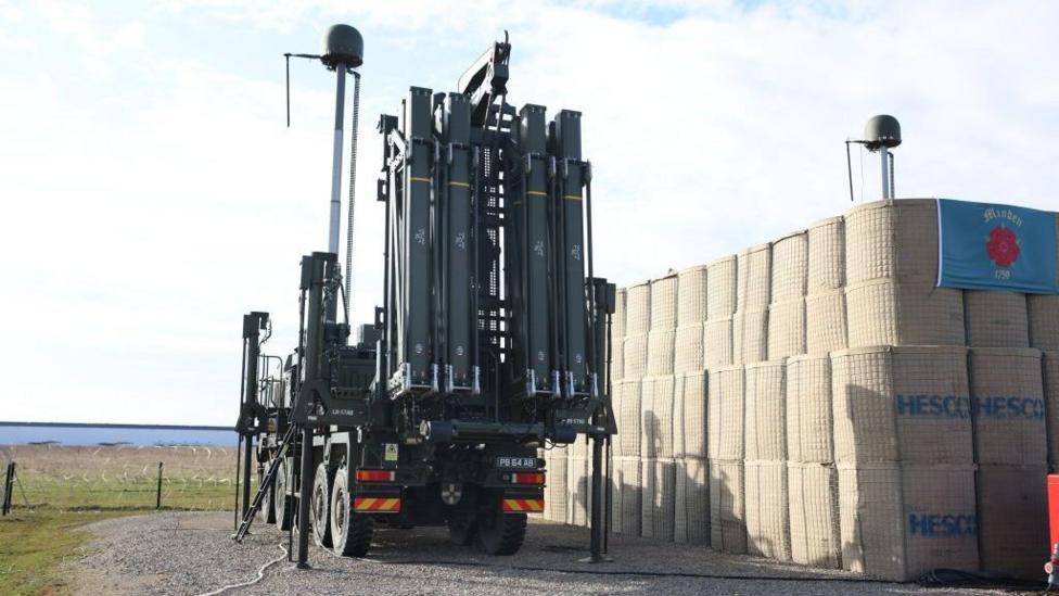 A missile defence system is seen on a truck with fields behind it.