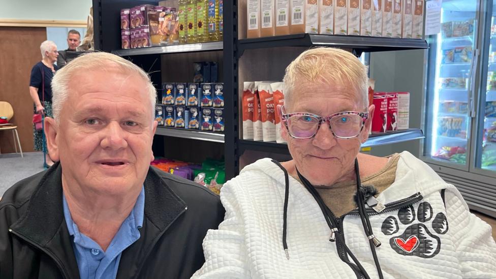 Rod Taffs and Shirley Graves inside the SEK Community Food Shop in Chatham with the freezer aisle to their left.
