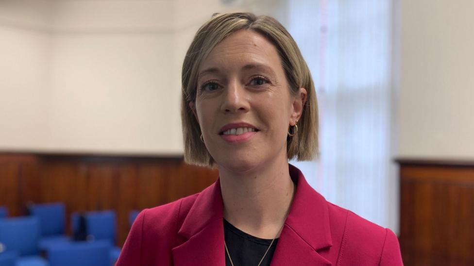 Deputy first minister Jenny Gilruth with short blonde/brown hair in a pink jacket with a black top underneath