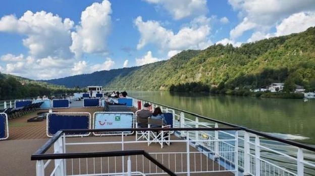 A picture taken from the top deck of a river cruise vessel, as it moves along the Danube.