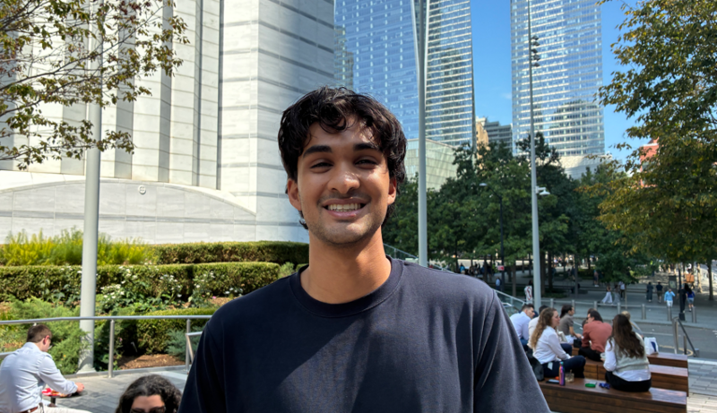 Vik, a young man with black wavy hair, smiles at the camera