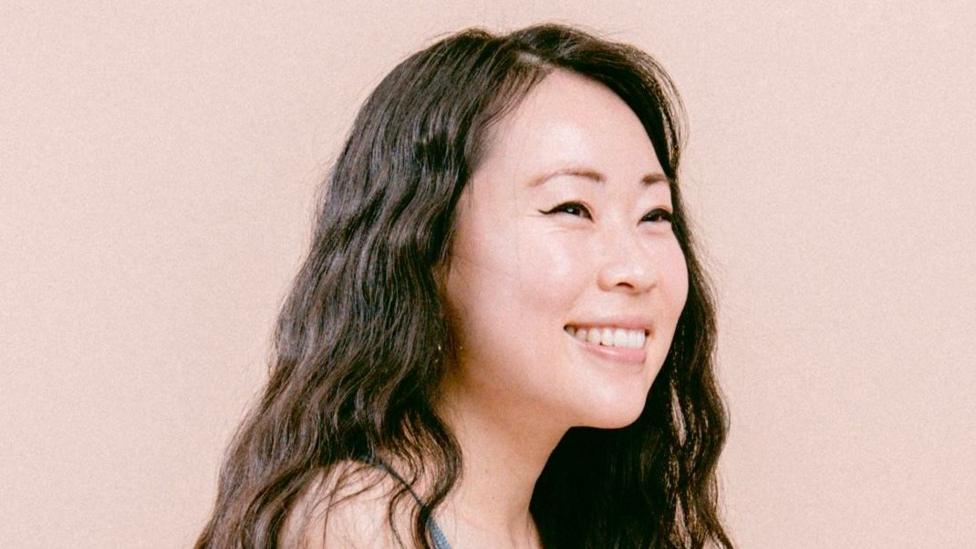 A woman with dark hair smiling.