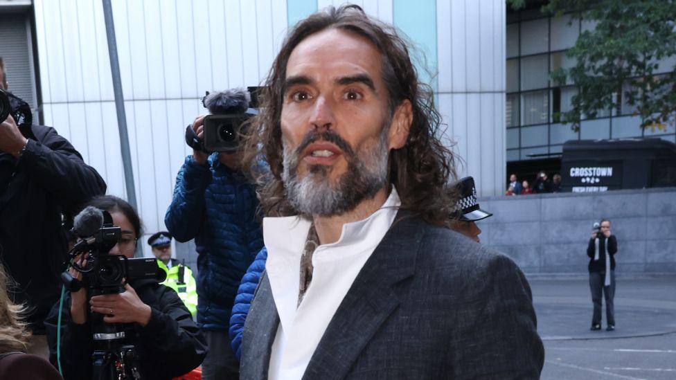 Russell Brand arrives at court ahead of his trial, where he faces rape and sexual assault charges at Southwark Crown Court on October 12, 2026 in London, England.