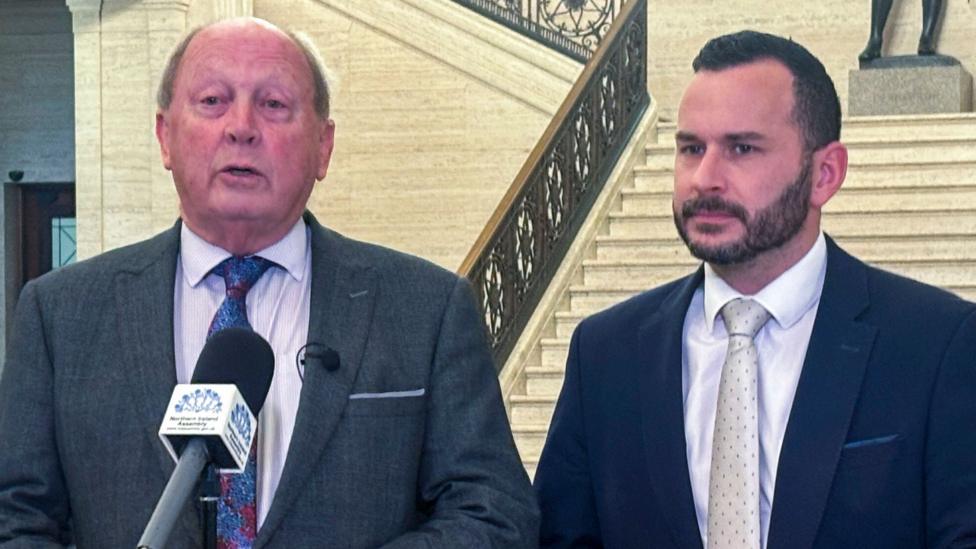 Two men standing at a microphone