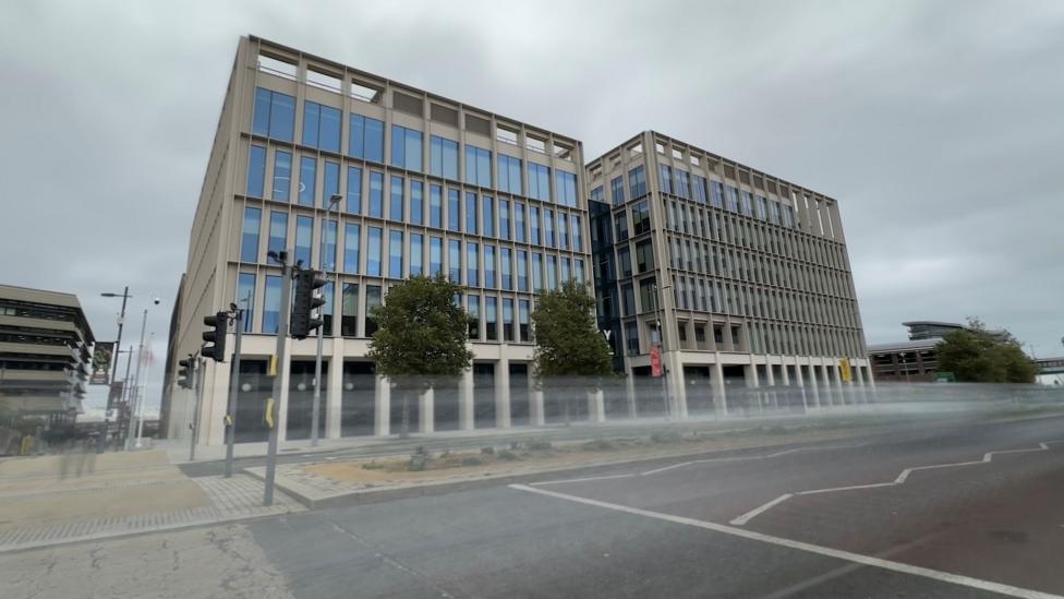 City Hall in Sunderland. It's a modern office block with lots of long windows, standing some five storeys high. A road is in front and cars are passing with a blurred effect.