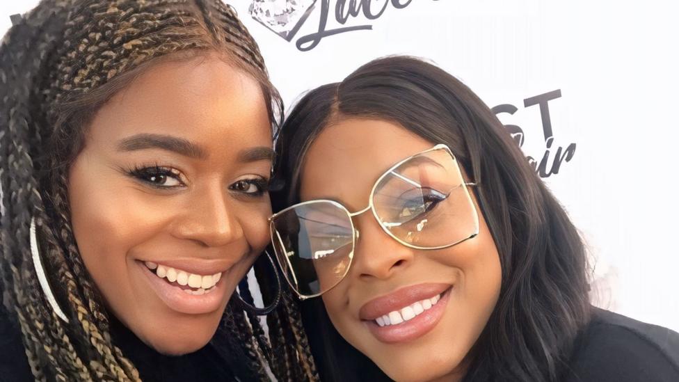 A close-up selfie of Antonia and actress Niecey Nash. Both are smiling and Niecey, who is on the right, is wearing a large pair of clear glasses. Her hair is black and long.