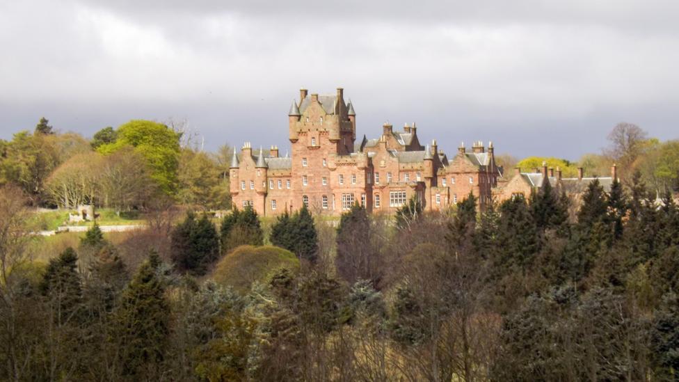 Ayton Castle in the Borders, a sandstone castle with many turrets surrounded by trees