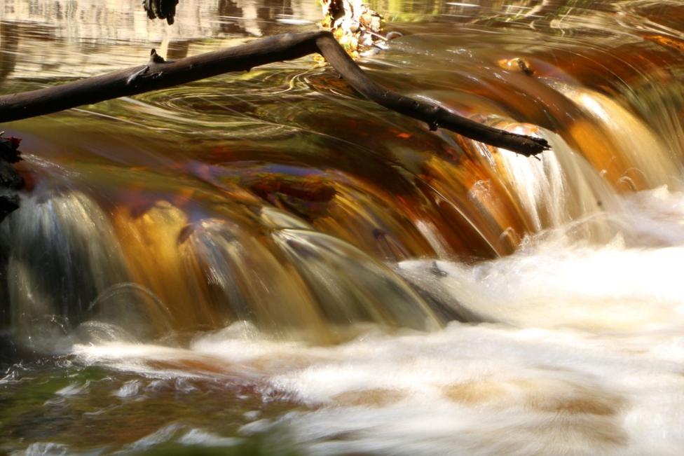 A long-exposure of a waterfall. The water has a red colour.
