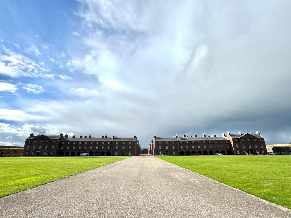 A large fort in two sections with a driveway in the foreground
