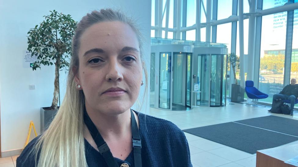 Photograph of Detective Constable Lisa McGaffin. She is pictured looking into camera, say in the reception area at the Greater Manchester Police force headquarters.