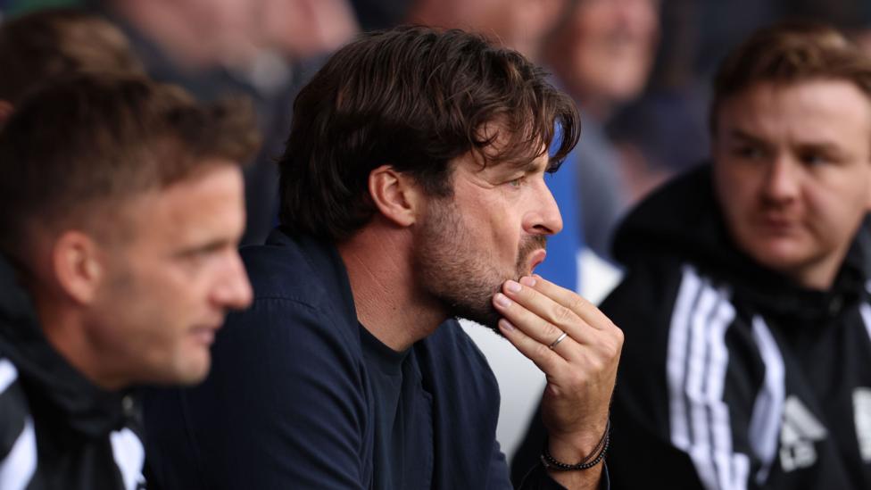 Russell Martin strokes his chin in the Leicester City dugout