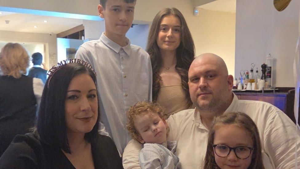 A family getting together for a photo at a party or event