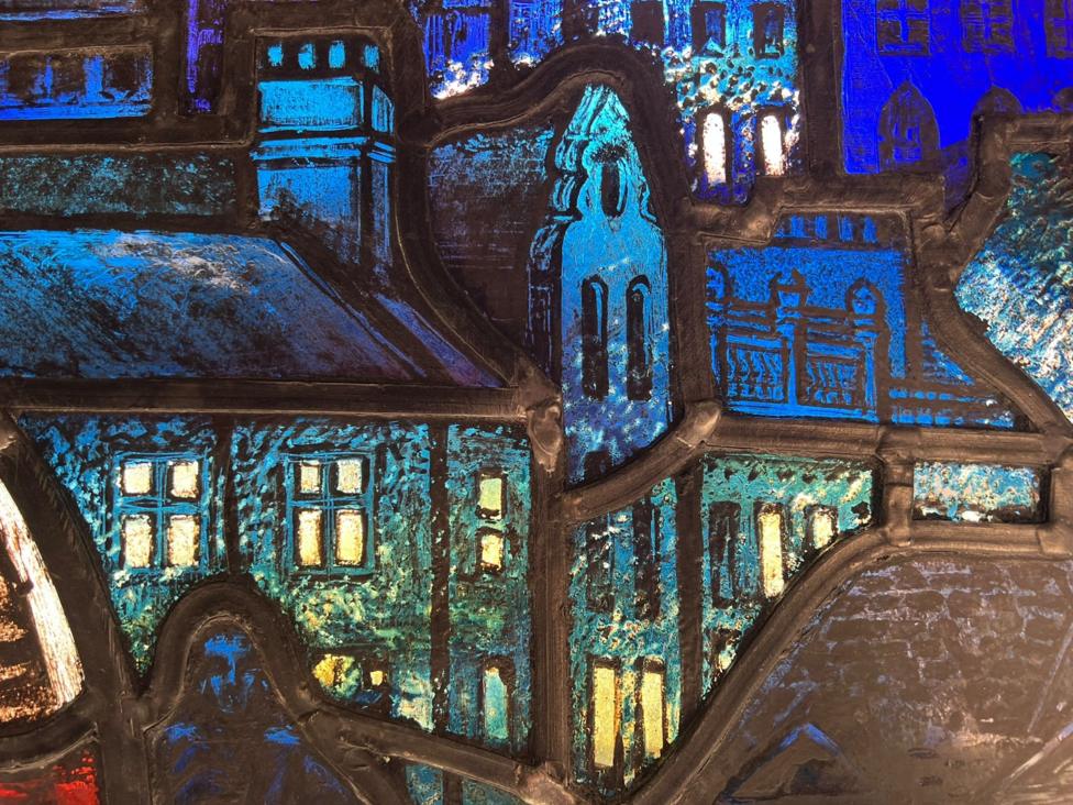 Stained-glass detail depicting Glasgow buildings in deep blue glass.