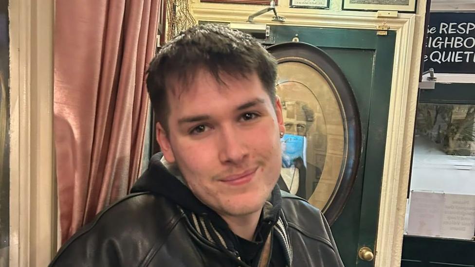 A young man in a black leather jacket. 