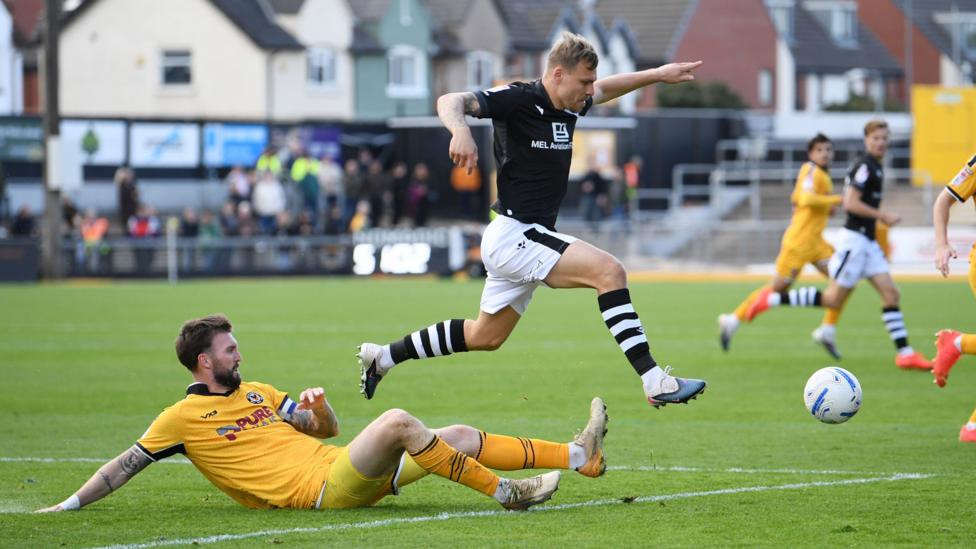 Kyle Cameron tackles Colchester United's Jack Tucker 