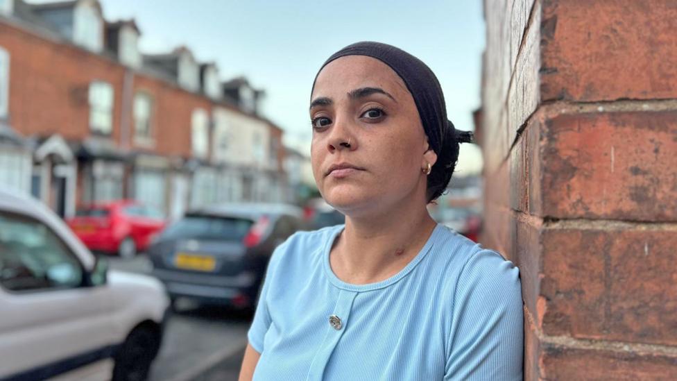 Photo: theukpulse.co.uk Alysha, who has a nose ring and a sky blue top, looks at the camera while leaning against a wall in Birmingham