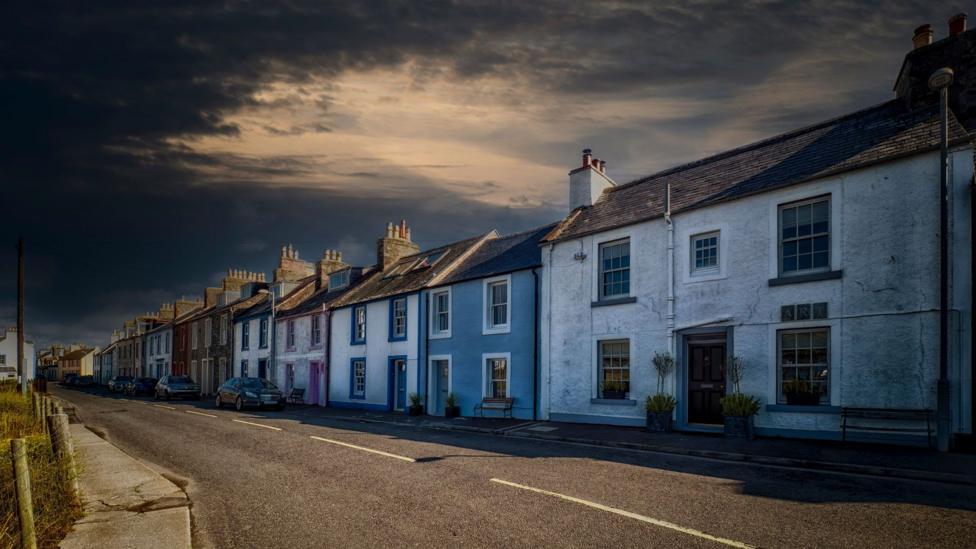 A row of houses in the Isle of Whithorn on what looks like a stormy day