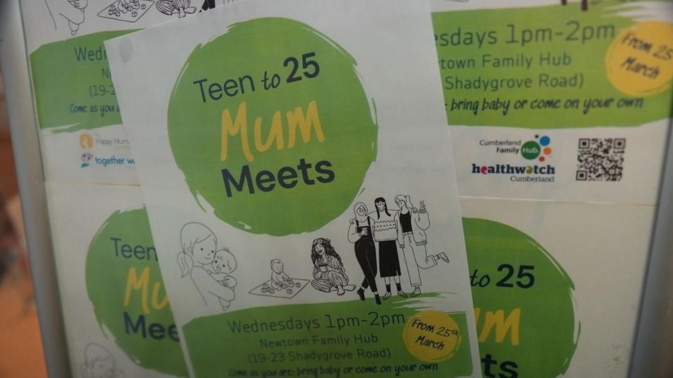 A poster displays the words 'Teen - 25 Mum Meets' along with drawings of mums and babies and women in an embrace. The poster is white and green, the drawings are in black and white.