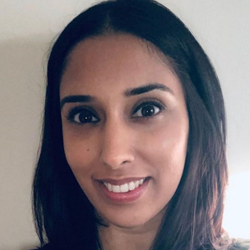 A selfie of a woman wearing a dark-coloured top and smiling at the camera.