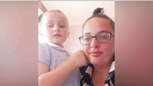 Mum Alex Doyle, wearing glasses, poses with her daughter Remi who playfully pretends to punch her