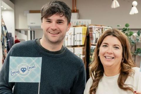 Brother and sister Jack Strachan and Shona Singer smiling at the camera inside a shop.