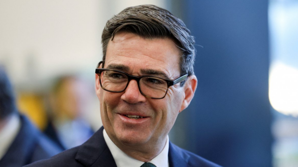 Andy Burnham wears a navy suit.