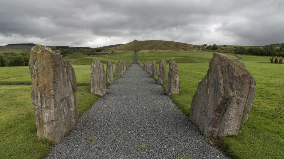 A view along a pathway with rocks lined up the sides