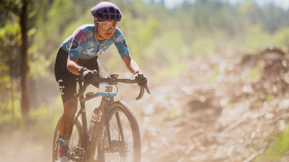A woman on her bike makes her way through the dusty landscape of Galloway