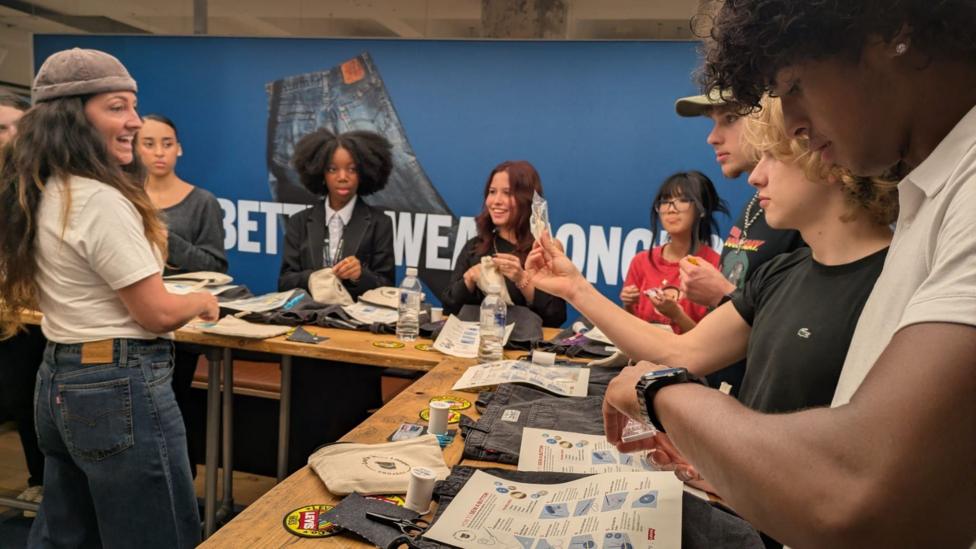 A group of young people at a workshop learning to sew